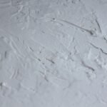 Close-up shot of a textured white plaster surface with rough details.